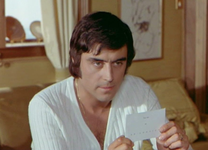 Ian McShane wearing a white Lacoste cardigan